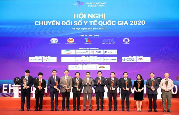 Phó Tổng Giám đốc Tập đoàn Huỳnh Quang Liêm (thứ 5 từ trái qua) đón nhận Cúp vinh danh đơn vị tiên phong trong chuyển đổi số y tế năm 2020